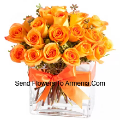 25 Roses Orange avec quelques fougères dans un vase en verre