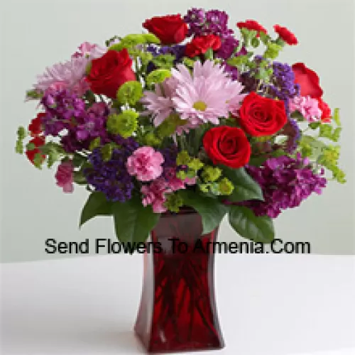 Red Roses, Pink Carnations And Other Assorted Seasonal Flowers In A Glass Vase