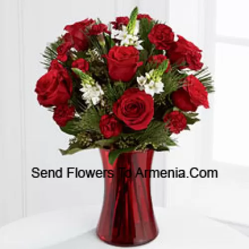 This romantic arrangement bristles with the passion and wonder of the Christmas season. Rich red roses and burgundy mini carnations accented with the snowy white blooms of Stars of Bethlehem, pine branches, and lush greens will easily sweep them off their feet. Arranged in a ruby red clear glass vase, this bouquet conveys your most heartfelt holiday wishes. (Please Note That We Reserve The Right To Substitute Any Product With A Suitable Product Of Equal Value In Case Of Non-Availability Of A Certain Product)